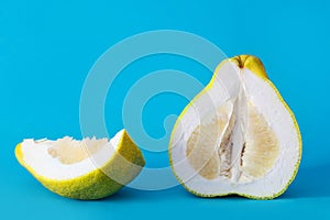 Sliced pomelo bright yellow green on a blue background