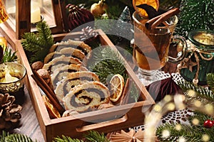 Sliced poppy seed roll in wooden box in rustic style and fruit compote for Christmas