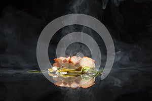Sliced pork on black background with smoke