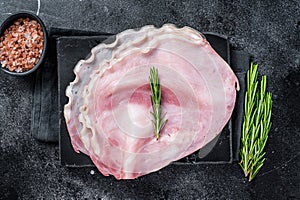 Sliced pork ham on marble board. Black background. Top view