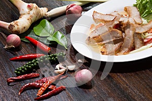 Sliced pork roasted Thai style with green salad on white plate