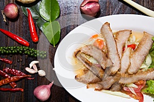 Sliced pork roasted Thai style with green salad on white plate