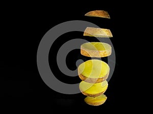 Sliced potato floating on black background