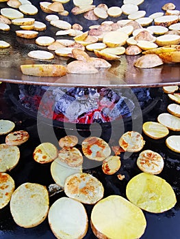 Sliced potatoes on the hot plate - hot embers