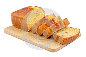 Sliced pound cake with lemon glaze on a cutting board isolated on a white background.