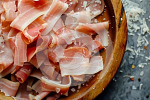 Sliced Prosciutto on Wooden Plate With Parmesan Shavings