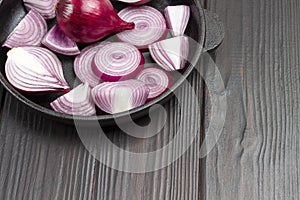 Sliced purple onions into rings and whole onion in frying pan