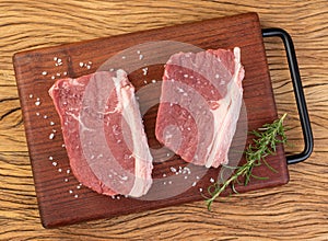 Sliced raw ancho beef, typical argentinian cut, over wooden board with seasonings