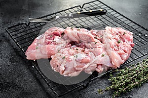 Sliced raw Chicken leg thigh fillet meat ready for cooking with spices. Black background. Top view