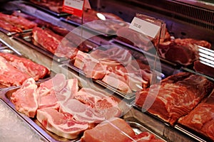 Sliced raw meat on a shelf in a supermarket.