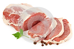 Sliced raw pork meat with parsley and peppercorns isolated on white background. top view