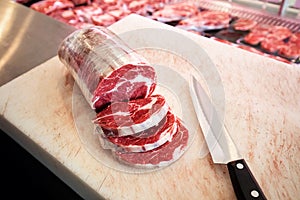 Sliced raw rib eye steak meat on the cutting board in a butcher shop