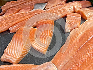 Sliced raw salmon or fresh salmon. Salmon fillets for sale at market displayed with a patchwork effect. Many fresh salmon fish