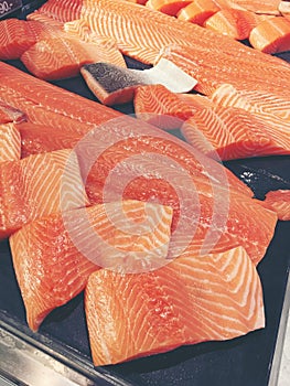 Sliced raw salmon or fresh salmon. Salmon fillets for sale at market displayed with a patchwork effect. Many fresh salmon fish