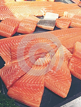 Sliced raw salmon or fresh salmon. Salmon fillets for sale at market displayed with a patchwork effect. Many fresh salmon fish