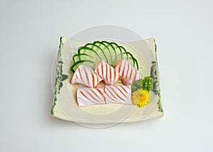 Sliced raw Salmon sac sashimi with cucumber on plate