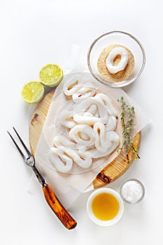 sliced raw squid rings with lime, olive oil, breadcrumbs. Preparation of Summer healthy snacks. on white