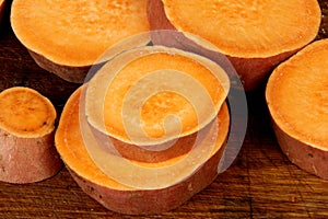 Sliced raw sweet potato with oil and spices on the baking paper, oven pan