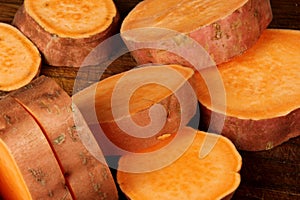 Sliced raw sweet potato with oil and spices on the baking paper, oven pan