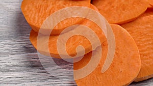 Sliced raw sweet potato tuber on a kitchen board. Nutritious uncooked ingredients.