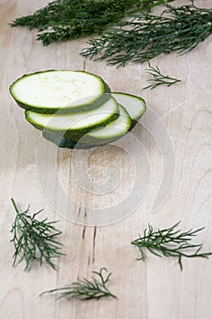 Sliced raw zucchini with fennel on the wooden background