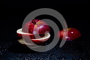 Sliced red apple isolated on black background.