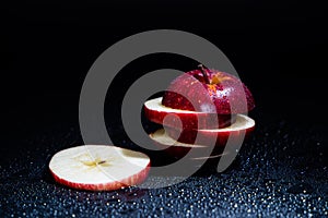 Sliced red apple isolated on black background.