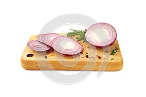 Sliced red onion with kitchen herbs and spices on wooden board over white