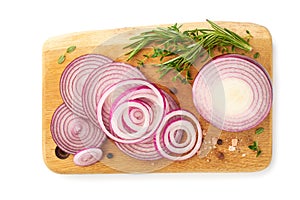 Sliced red onion with kitchen herbs and spices on wooden board over white