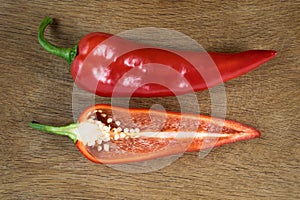 Sliced red sweet pepper isolated on wooden background