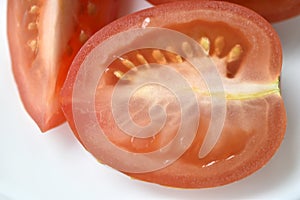 Sliced red tomatoes close-up on a plate