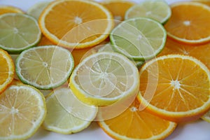 Sliced rings of orange and lemon, and lime isolated on white background