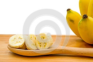 Sliced of ripe cultivated bananas on the wooden spoon that isolated on a white background