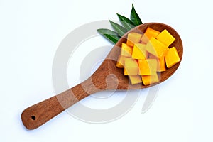 Sliced ripe mango cubes on wooden spoon on white