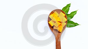 Sliced ripe mango cubes on wooden spoon on white background