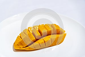 sliced ??ripe mango on a white plate