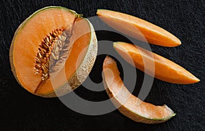 Sliced ripe melon on black background