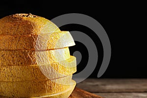 Sliced ripe melon on table against black background, closeup