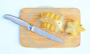 Sliced ripe Star apple on wood board background against white background