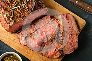 Sliced Roast beef on cutting board with grilled vegetables. Top
