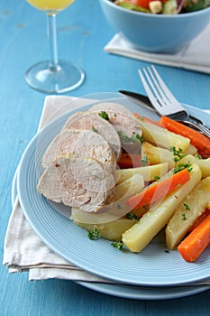 Sliced roast pork tenderloin with potatoes and carrots