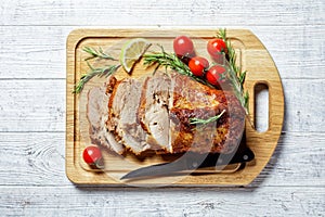 Sliced roasted pork on a white wooden background photo