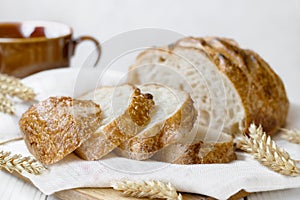 Sliced round wheat bread on board on table selective focus