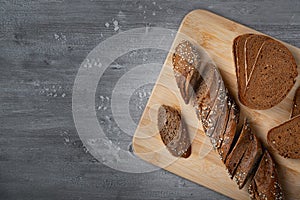 Sliced rye bread on a wood cutting board with grain
