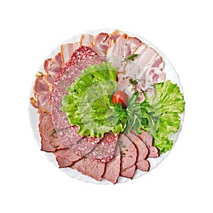 Sliced salami, bacon and ham with vegetables on a plate isolated. Top view