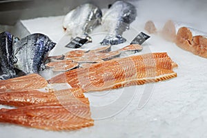 Sliced salmon, steaks, fish pieces lying on ice