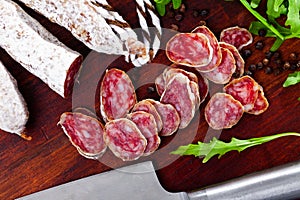 Sliced sausage fuet with herb on table