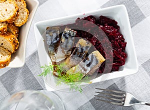Sliced scomber with grated beetroot served on table