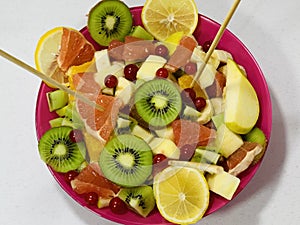 Sliced seasonal fruits on a wooden skewer