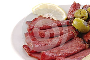 Sliced served sausage with raw lemon